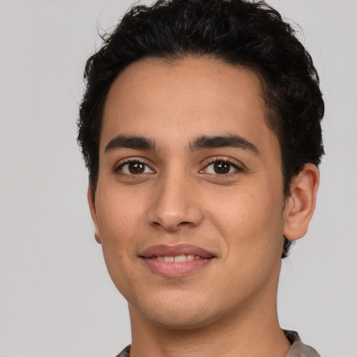 Joyful latino young-adult male with short  black hair and brown eyes