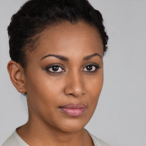 Joyful black young-adult female with short  brown hair and brown eyes