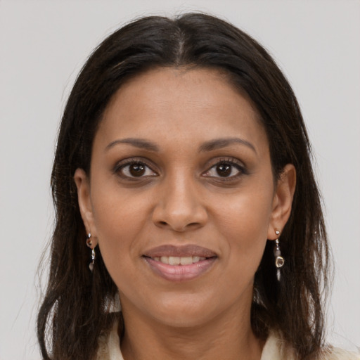 Joyful black young-adult female with long  brown hair and brown eyes
