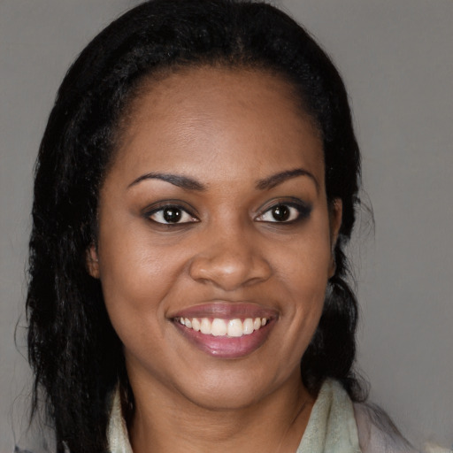 Joyful black young-adult female with long  brown hair and brown eyes