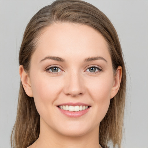 Joyful white young-adult female with medium  brown hair and grey eyes