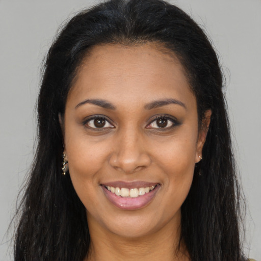 Joyful black young-adult female with long  brown hair and brown eyes