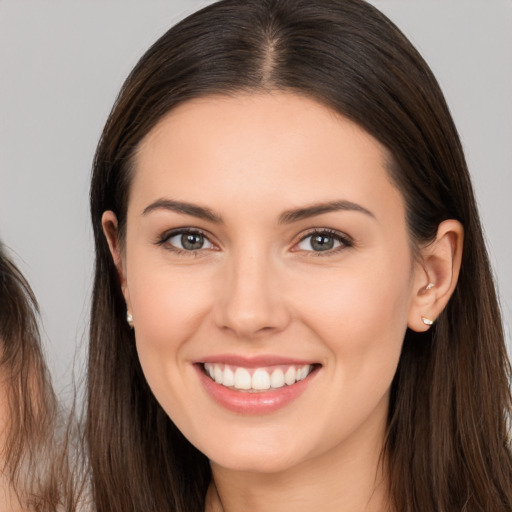 Joyful white young-adult female with long  brown hair and brown eyes