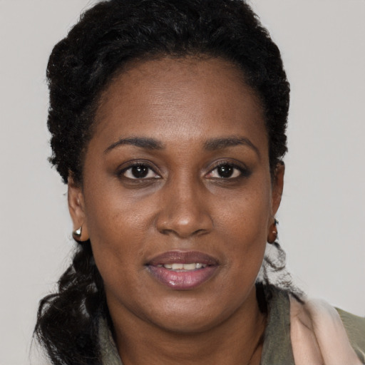 Joyful black adult female with long  brown hair and brown eyes