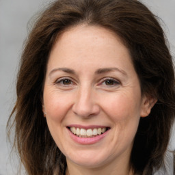 Joyful white adult female with long  brown hair and brown eyes