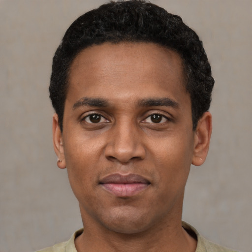 Joyful black young-adult male with short  black hair and brown eyes