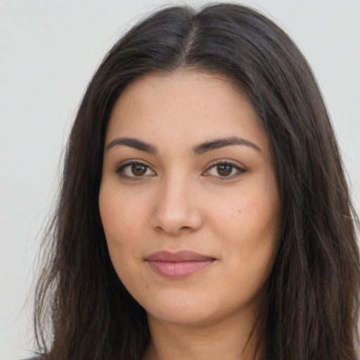 Joyful latino young-adult female with long  brown hair and brown eyes