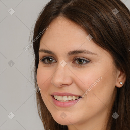 Joyful white young-adult female with long  brown hair and brown eyes