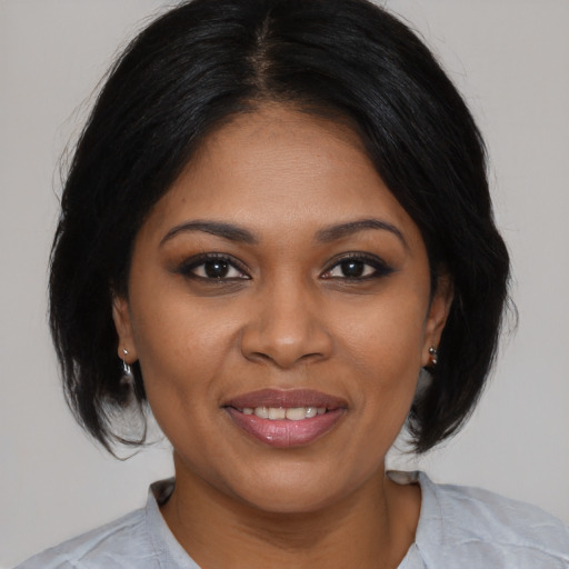 Joyful black young-adult female with medium  brown hair and brown eyes