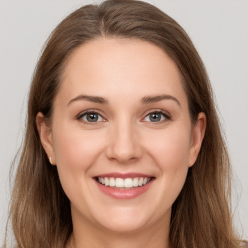 Joyful white young-adult female with long  brown hair and grey eyes