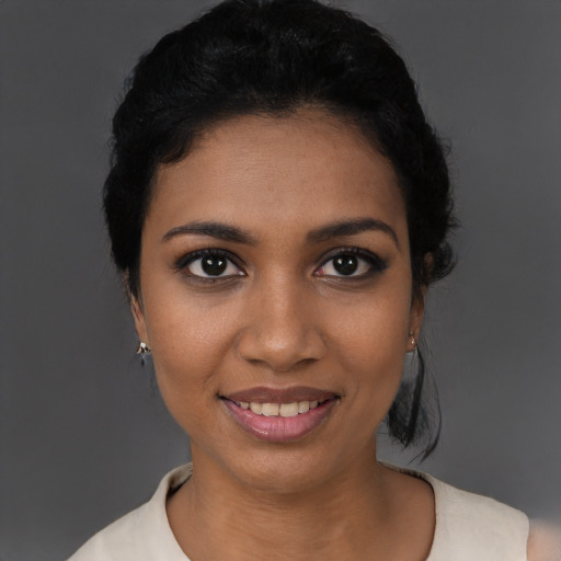 Joyful black young-adult female with short  black hair and brown eyes
