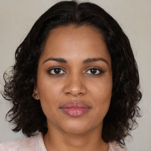 Joyful black young-adult female with medium  brown hair and brown eyes