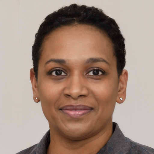 Joyful black adult female with short  black hair and brown eyes
