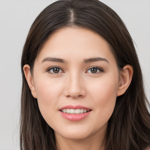 Joyful white young-adult female with long  brown hair and brown eyes