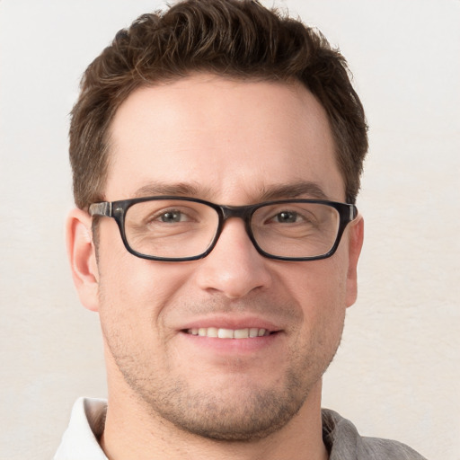 Joyful white young-adult male with short  brown hair and grey eyes