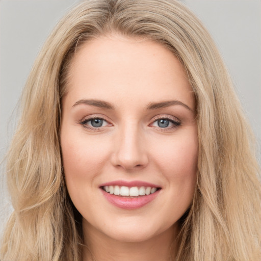 Joyful white young-adult female with long  brown hair and blue eyes