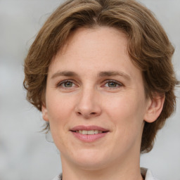 Joyful white adult female with medium  brown hair and grey eyes