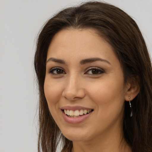 Joyful white young-adult female with long  brown hair and brown eyes