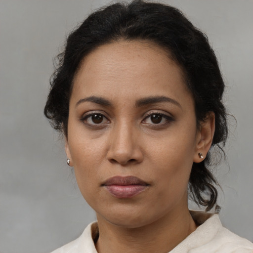 Neutral latino adult female with medium  brown hair and brown eyes