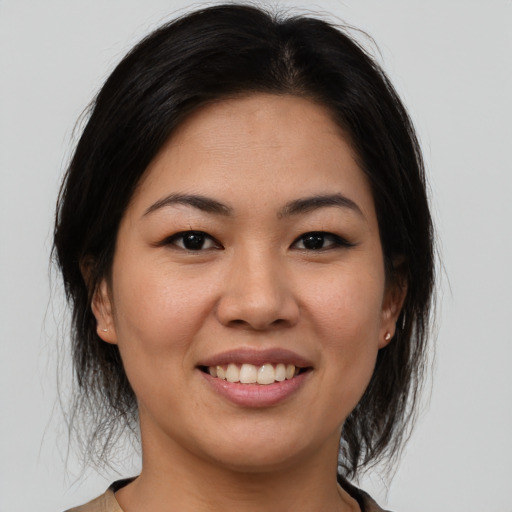 Joyful latino young-adult female with medium  brown hair and brown eyes