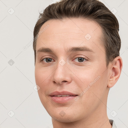 Joyful white young-adult male with short  brown hair and grey eyes