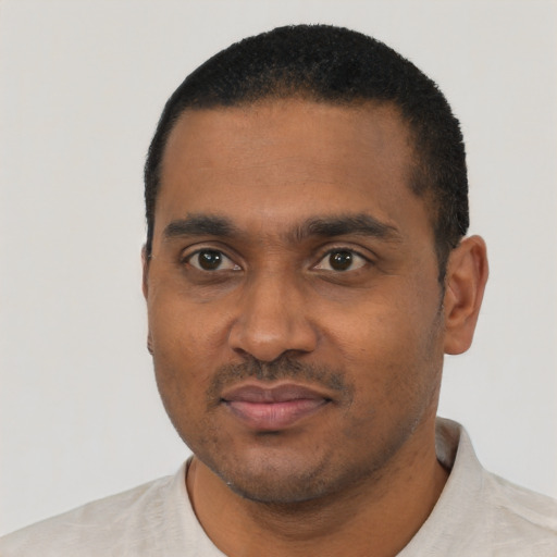 Joyful black young-adult male with short  black hair and brown eyes