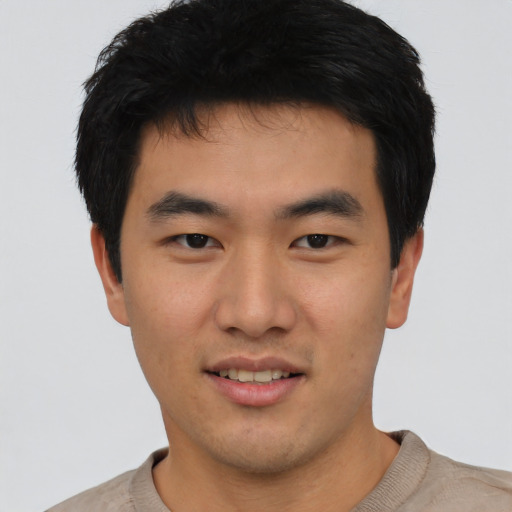 Joyful asian young-adult male with short  black hair and brown eyes