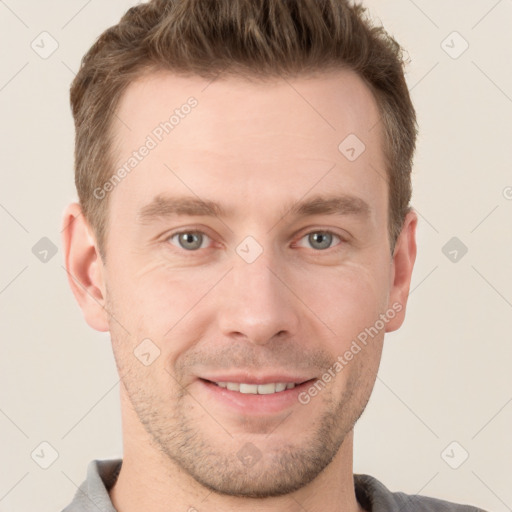 Joyful white young-adult male with short  brown hair and grey eyes