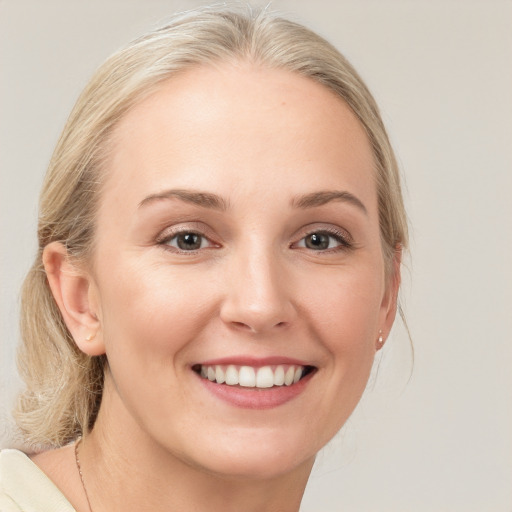 Joyful white young-adult female with medium  blond hair and blue eyes