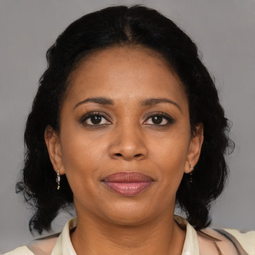 Joyful black adult female with medium  brown hair and brown eyes