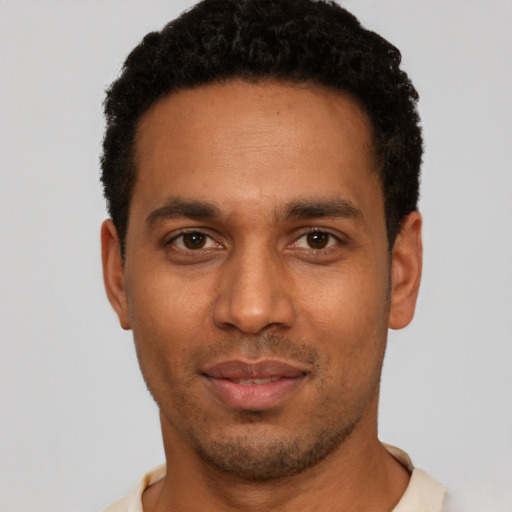 Joyful black young-adult male with short  black hair and brown eyes