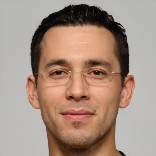 Joyful white young-adult male with short  black hair and brown eyes