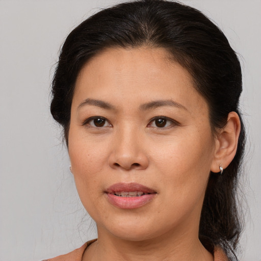 Joyful asian adult female with medium  brown hair and brown eyes