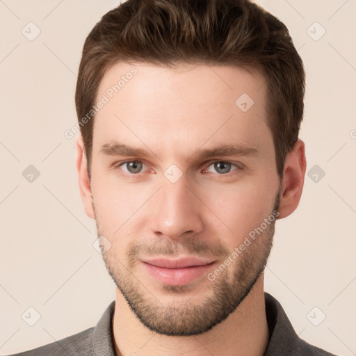 Joyful white young-adult male with short  brown hair and grey eyes