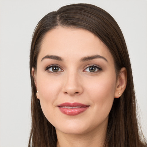 Joyful white young-adult female with long  brown hair and brown eyes