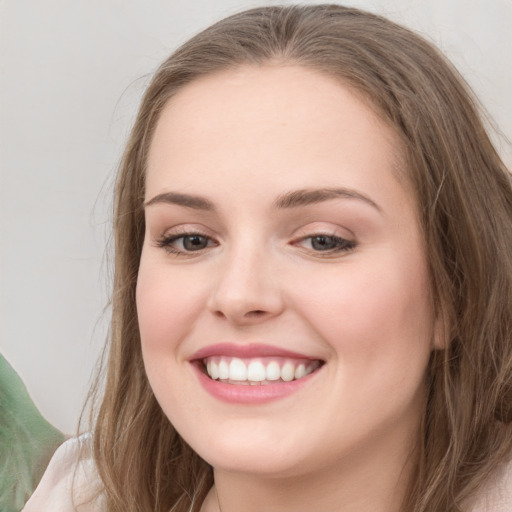 Joyful white young-adult female with long  brown hair and green eyes