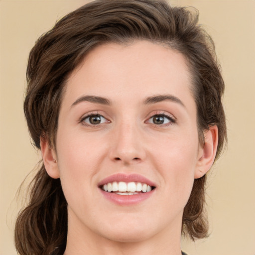 Joyful white young-adult female with medium  brown hair and green eyes