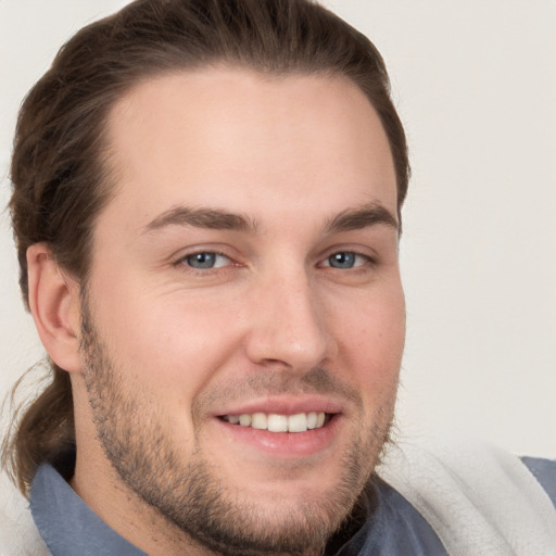 Joyful white young-adult male with short  brown hair and grey eyes