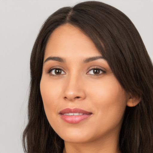 Joyful latino young-adult female with long  brown hair and brown eyes