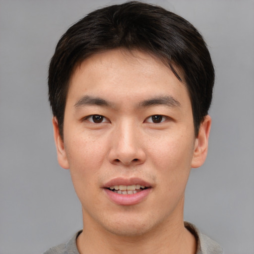 Joyful asian young-adult male with short  brown hair and brown eyes