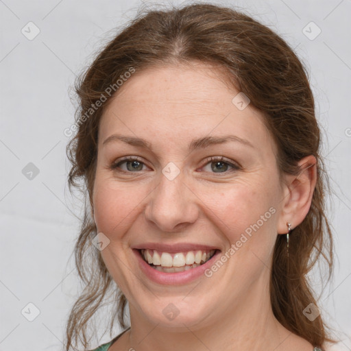 Joyful white adult female with medium  brown hair and grey eyes