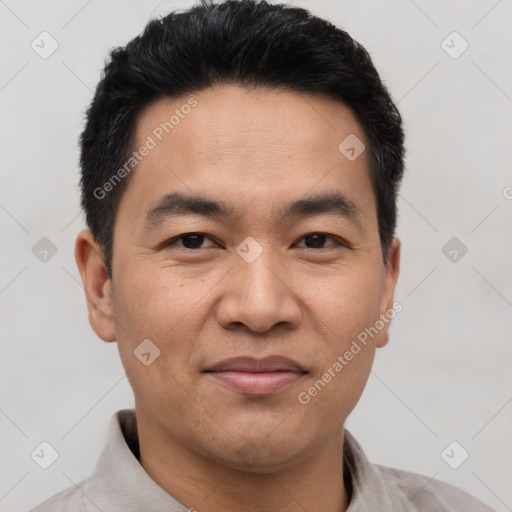 Joyful asian adult male with short  black hair and brown eyes