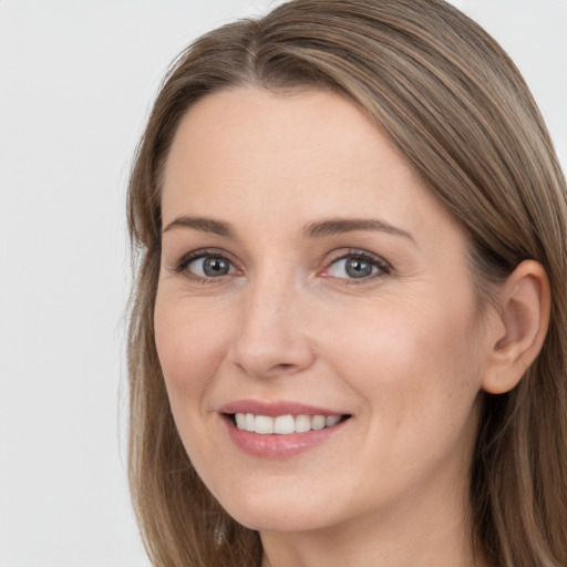 Joyful white young-adult female with long  brown hair and grey eyes