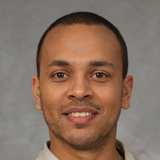 Joyful latino young-adult male with short  brown hair and brown eyes