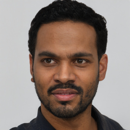 Joyful black young-adult male with short  black hair and brown eyes