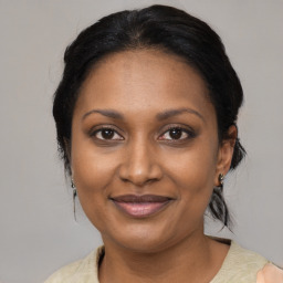 Joyful black adult female with medium  brown hair and brown eyes