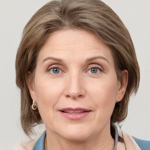 Joyful white adult female with medium  brown hair and grey eyes