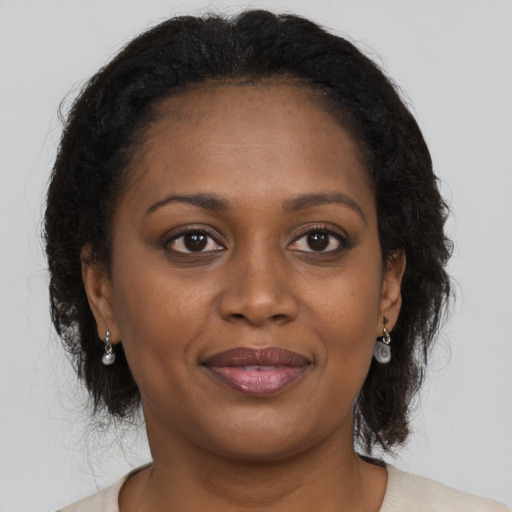 Joyful black young-adult female with medium  brown hair and brown eyes