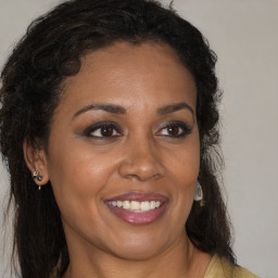 Joyful black young-adult female with long  brown hair and brown eyes