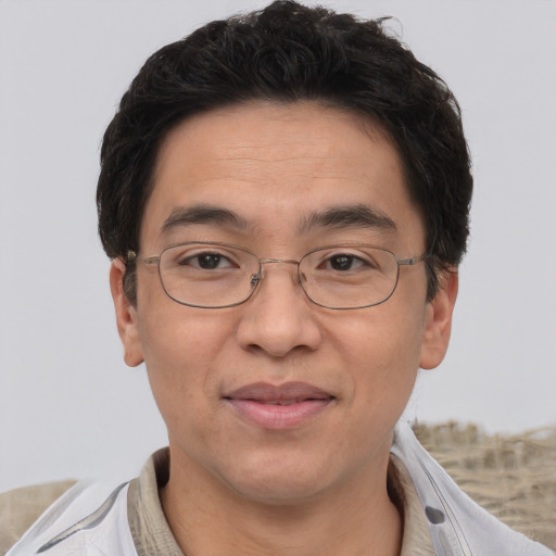Joyful asian adult male with short  brown hair and brown eyes